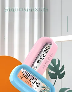 Macro view of digital table clocks in pink and blue showing date, time and temperature