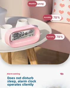Macro shot of pink digital alarm clock showing temperature humidity and weather icons