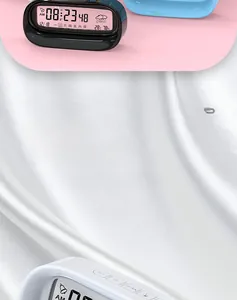 Close-up of smart digital alarm clock with transparent display showing temp and humidity