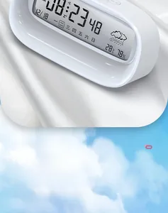 Modern white digital alarm clock detail showing large LCD screen with weather icons