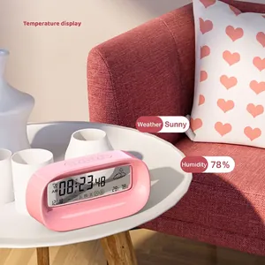 Pink smart digital alarm clock showing time, temperature and weather on bedside table