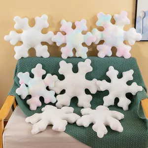 Cute snowflake plush pillows in white and tie-dye colors on a cozy sofa for home decor