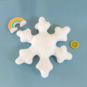 Close-up of white snowflake plush pillow with soft sherpa texture on light blue background