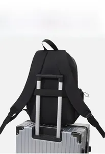 Detail der Kofferschlaufe eines schwarzen Laptop-Rucksacks auf einem Koffer montiert