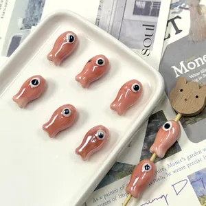 Macro detail of handmade fish ceramic beads for DIY jewelry making on white tray