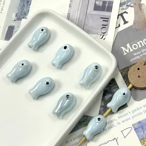 Close-up of light blue ceramic fish-shaped beads for handmade DIY jewelry and craft