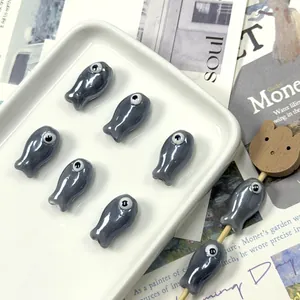 Macro detail of fish-shaped ceramic beads with pearl finish for DIY jewelry