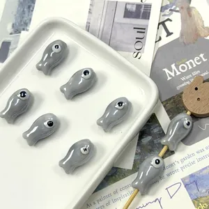 Macro shot of fish-shaped ceramic beads for DIY jewelry making on white tray