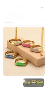 Detail view of gold-plated titanium rings featuring polished colorful shell inlay inserts