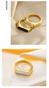 Detailed view of gold plated geometric rings with black and white inlay on silk