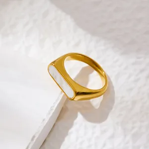 Minimalist gold titanium steel ring with rectangular mother of pearl inlay on marble base