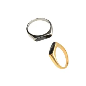 Gold and silver stainless steel signet rings with black oval inlay on white background