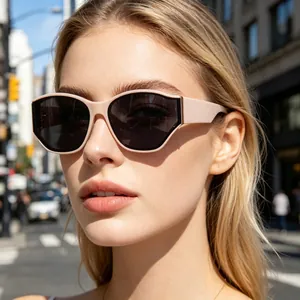 Close-up of nude pink polygon sunglasses with dark grey lenses worn by a model in the city