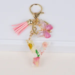 Detailed view of floral resin letter Y keychain with pink tassel and gold butterfly charm