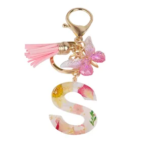 Letter S keychain with real dried flowers, pink tassel, and butterfly charm on gold ring