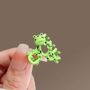 Close-up of a green cartoon frog hair claw clip showing the glossy finish and small size