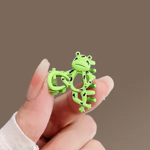 Close-up of a mini green cartoon frog hair claw clip showing compact size and glossy finish