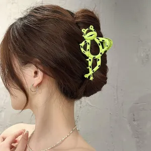 Detail view of a large green frog hair claw clip holding a secure bun on a woman head