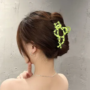 Detail showing a creative fluorescent green frog claw clip on a low bun hairstyle