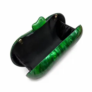 Detail view of acrylic evening bag with green marble texture and black interior lining