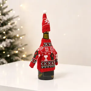 Close-up of a Christmas wine bottle cover with red knit sweater and pom-pom hat decor
