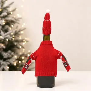 Detail of red knitted Christmas wine bottle sweater and mini hat with festive patterns
