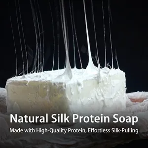 Handmade goat milk silk protein soap showing a rich stretching texture on black background