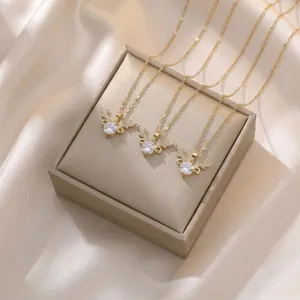 Three gold elk horn necklaces with round zircons on beige gift box and satin