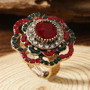 Bohemian retro floral ring with red gemstone and colorful crystals on wood background