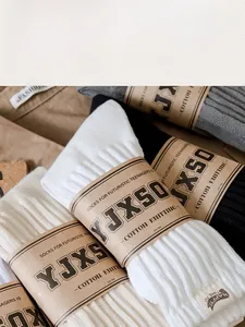 Macro detail of ribbed cotton knitting texture and vintage paper wrap on stacked socks