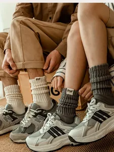 Detailed close-up of retro ribbed knit crew socks in beige and dark grey cotton blend