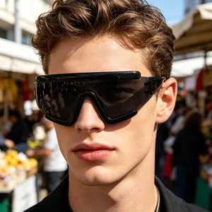 Close-up of black oversized cycling sunglasses with dark lenses on a male model