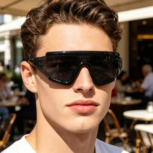 Close-up of black shield cycling sunglasses with dark lenses on a model's face