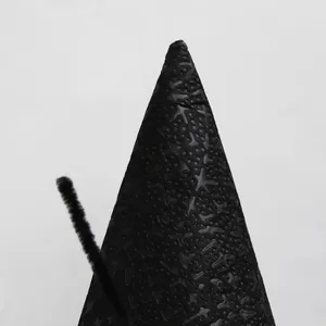 Macro shot of black Halloween wizard hat with detailed star patterns and soft plush wire