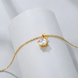 Macro detail of 18K gold plated necklace with classic six-prong cubic zirconia pendant