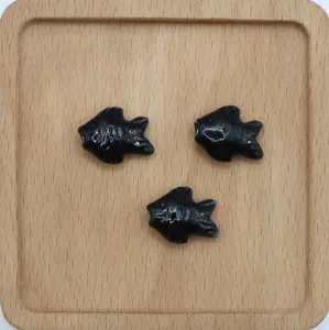 Tre perline in ceramica a forma di pesce nero su vassoio in legno per gioielli DIY
