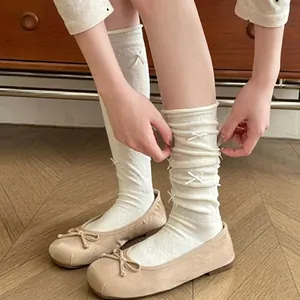 Detail of cream white mid-calf socks featuring delicate 3D bow accents and versatile styles
