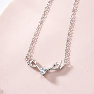 Elegante collana con corna di cervo e ciondolo in zircone su sfondo rosa da donna