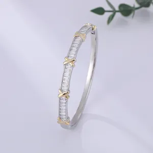 Luxurious gold plated crisscross bangle with sparkling cubic zirconia baguette stones