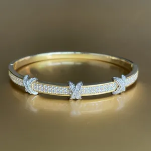 Luxurious gold plated crossover bangle featuring sparkling pavé diamonds in an elegant X design