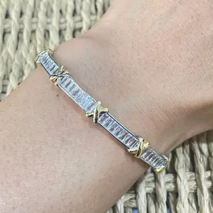 Detail of two-tone crossover bangle with sparkling crystals on wrist close-up view