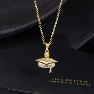 Macro shot of custom gold graduation necklace with engraved cap and yellow gemstone