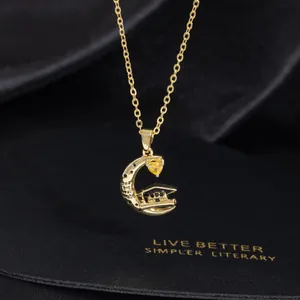 Detail of moon graduation necklace with yellow heart zircon and doctoral cap charm
