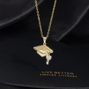 Detail of graduation necklace with golden mortarboard charm and heart crystal pendant