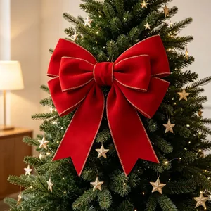 Large red velvet Christmas bow with gold stitched edges on top of a Christmas tree