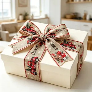 Detail of Christmas linen ribbon with red truck and bells tied on a white gift box