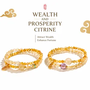 Detailed view of two yellow citrine beaded bracelets with a golden lock pendant