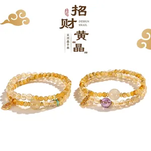 Detailed view of two yellow citrine beaded bracelets with a golden lock pendant