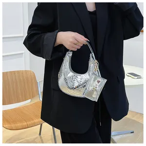 Detail of silver snake-pattern hobo bag with a matching mini zip pouch on a black blazer