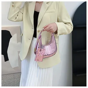 Detailed shot of pink snake pattern moon bag with small charm on yellow suit